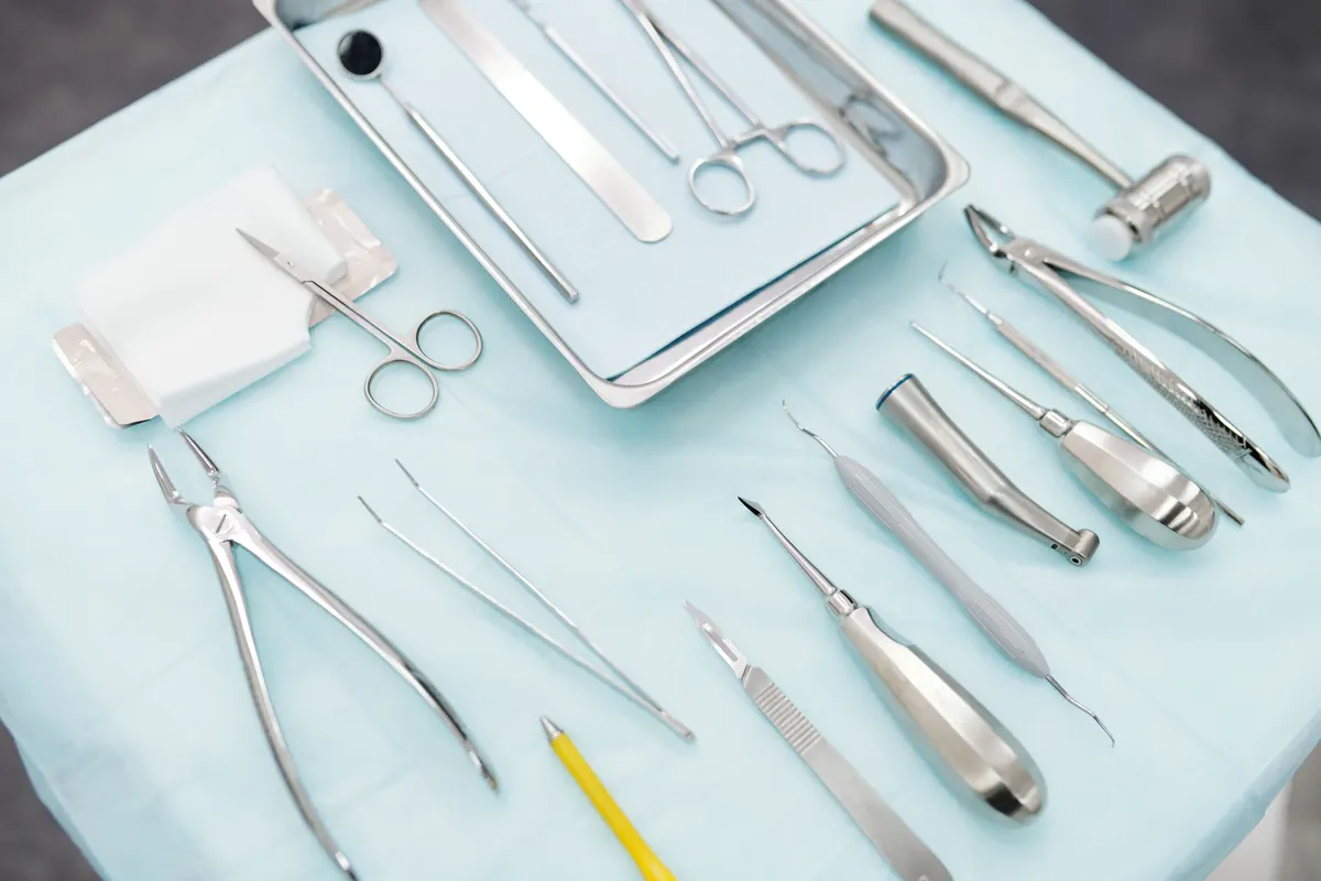 Extraction forceps, elevators and other surgical instruments laid out on a sterile tray.
